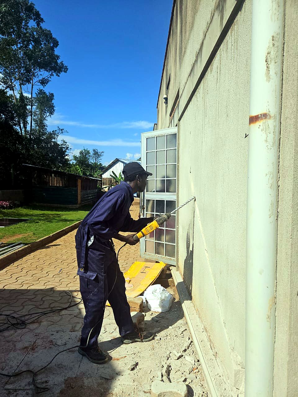 Technician installing an outdoor air-conditioning unit against a building wall