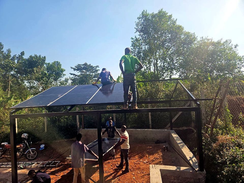 Crew assembling a raised steel solar carport structure